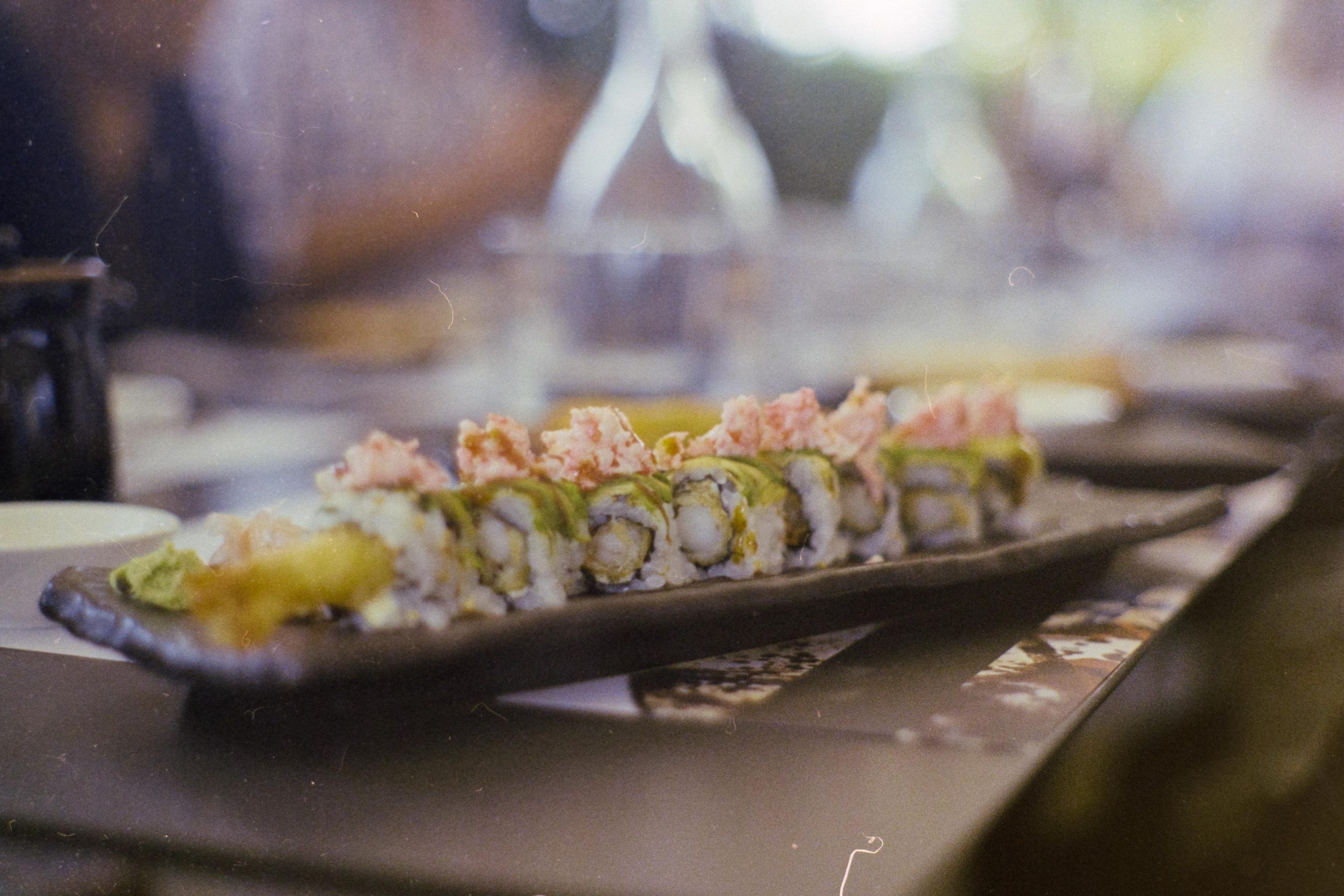 A sushi roll on a table with black tableware