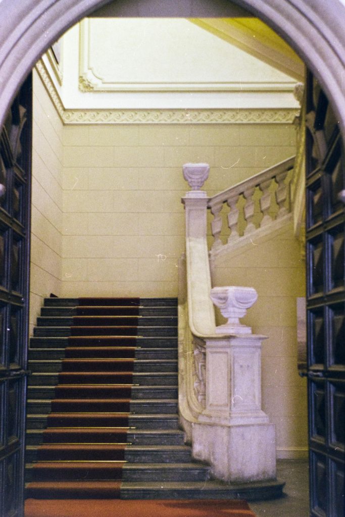 an old granite stairway with a red carpet inside a building