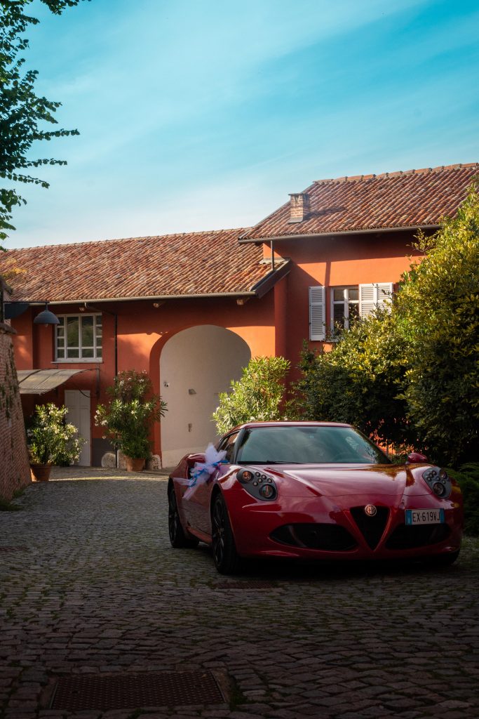 A red sports car in front of a villa