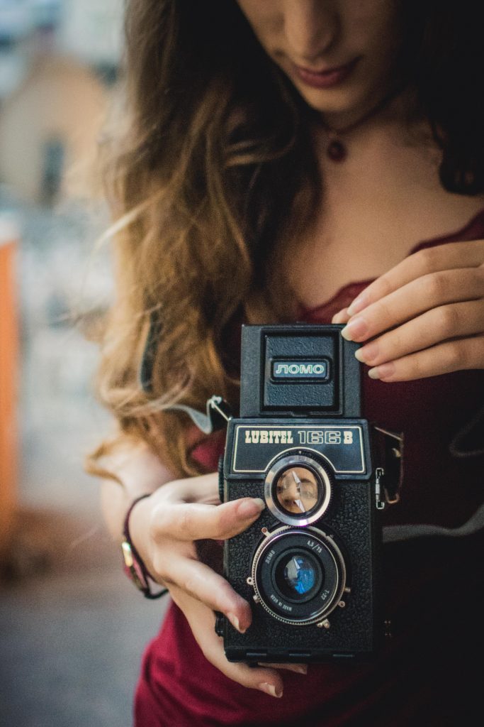 A girl holding a vintage camera