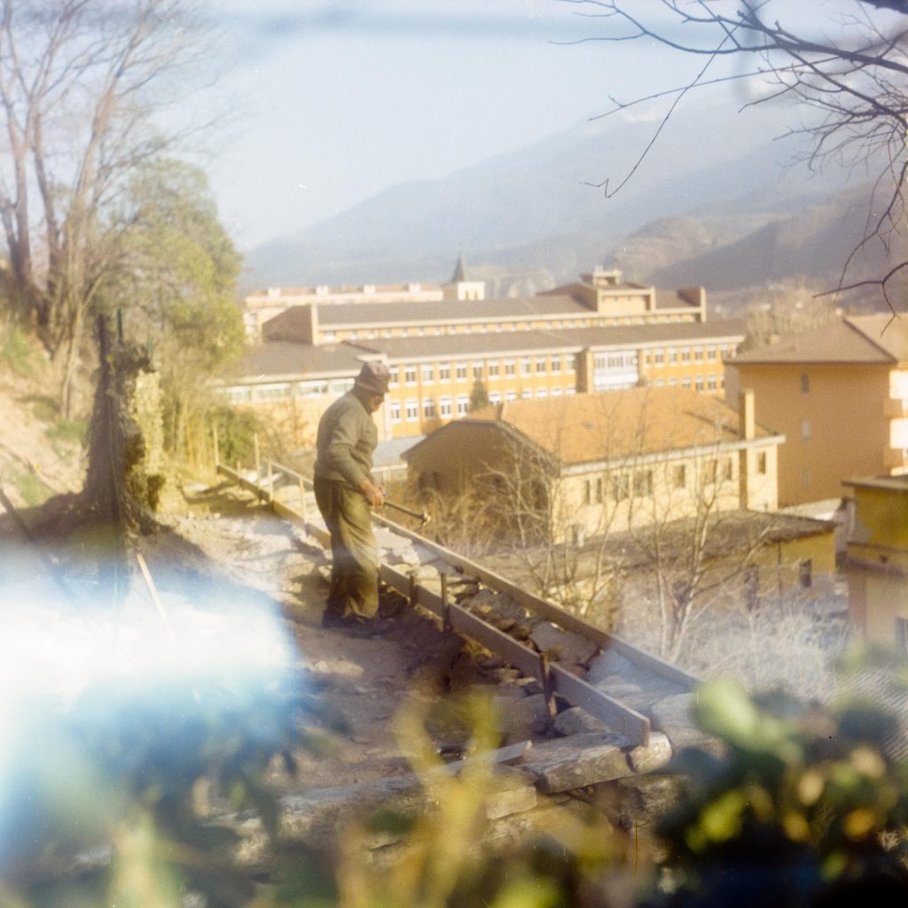 My grandpa working in a small garden on top of the town at Sunset 